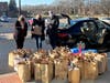 Kathy Fielding, CEO of the NSYMCA; and Kim Nyren, the NSYMCA Director of Community Investment; and Henry Fetta, Director/Vice President of the Hunger Resource Network pack up the bags of groceries donated to “Adopt a Student and Feed Their Family.” 