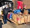 Henry Fetta, Director/Vice President of the Hunger Resource Network; Dan Jariabka, Founder of the Hunger Resource Network; and Kim Nyren, the NSYMCA Director of Community Investment display groceries donated to “Adopt a Student and Feed Their Family."