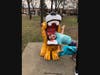 A participant in the Community Scavenger Hunt poses at the lion fountain in Village Green.