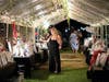 Guests from the NSYMCA’s Community Strong “Dinner under the Stars” fundraiser browse the final call of the night under the silent auction tent that had over 225 items and packages. 
 
