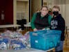 Shannon Sliwinski and Sean Fielding, pack “Blessing Bags” at the 2021 Holiday Giveback.