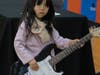 A young girl tries out an electric guitar at the School of Rock table at the NSYMCA Youth Explorer Expo on Sunday, January 12.