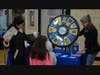 A family spins the wheel of prizes with Liz Jones from EverSmiles Orthodontics (located in Northbrook) at the NSYMCA Youth Explorer Expo on Sunday, January 12
