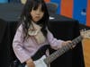 A young girl tries out an electric guitar at the School of Rock table at the NSYMCA Youth Explorer Expo on Sunday, January 12.