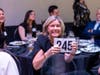 Kathy Rubash from Allstate Insurance Company raises her bidder number in effort to raise money for the North Suburban YMCA.