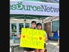 Photo 2: (Left to right)  Samantha Mallahan, HRN’s Students Helping Students Founder, and Ellen Park proudly hold up signs at Westmoor during the HRN’s Students Helping Students Campaign in 2024. 