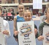 (Front to back) Nikol Dolhina and Hannah Popkov proudly hold their NSYMCA sign at the Illinois XCEL State Championship in Bloomington, IL. 
