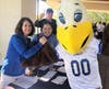Volunteers and school’s eagle mascot welcomed the golfers: Debbie McGregor, Maria Barrera and Chris Stiles