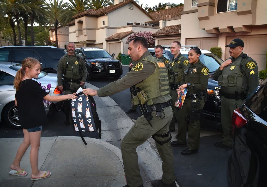Mission Viejo Police Services deputies surprise Regan with a new school backpack.