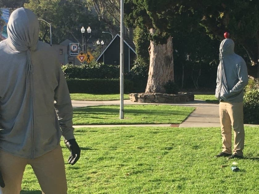 Five guys wearing hoodies are standing outside of city hall in Laguna Beach.