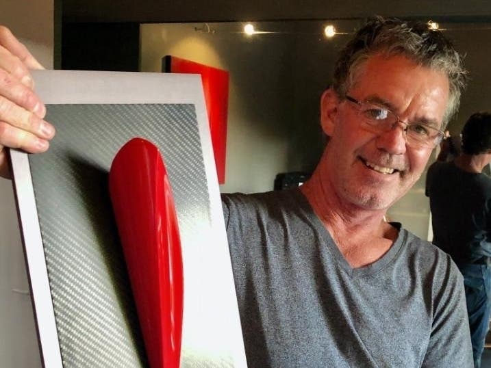 The artist with his sculpture, "It is Finished",  Ren Shape, painted Scuderia Rosso (authentic Ferrari red) on matte carbon fiber with polished industrial bearing on aluminum hard anodized plate. 