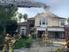 OCFA Firefighters attack the Laguna Hills house fire from the roof and within.