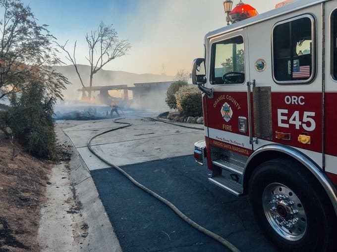 The Bond Fire began amid a Santa Ana gale with 31 structures lost, 21 damaged & 2 firefighters hurt. More strong winds arrive Monday night.