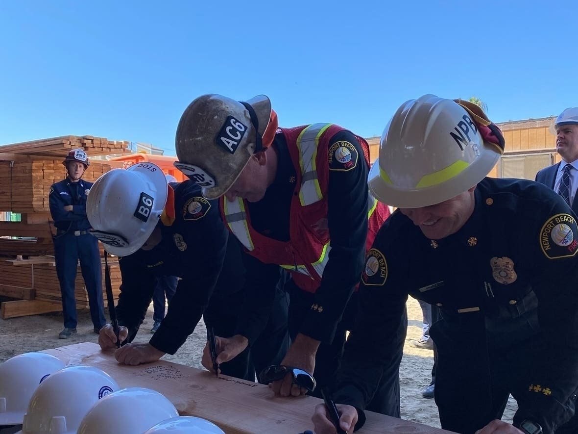 Newport Beach Firefighters wrote messages and signed their names to a beam that was installed to "top out" the new Station 2.