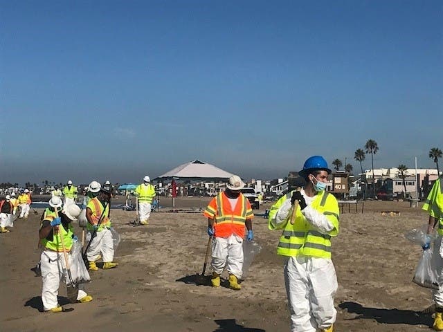 Workers descend on Newport Beach and surrounding beaches to pick tarballs out of the sand and deal with the ongoing oil spill crisis.
