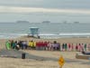 Volunteers lined up on the shore of Huntington Beach Thursday learning how to handle hazmat tar and oil before they go to work.