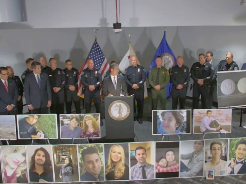 Orange County District Attorney Todd Spitzer, surrounded by victims' families, local dignitaries, discussing fentanyl deaths equitable to murder.