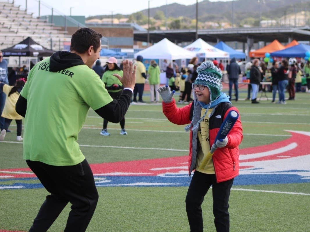 Myles Willis gives a high five to a volunteer at the city-sponsored Temecula Special Games, 2022.