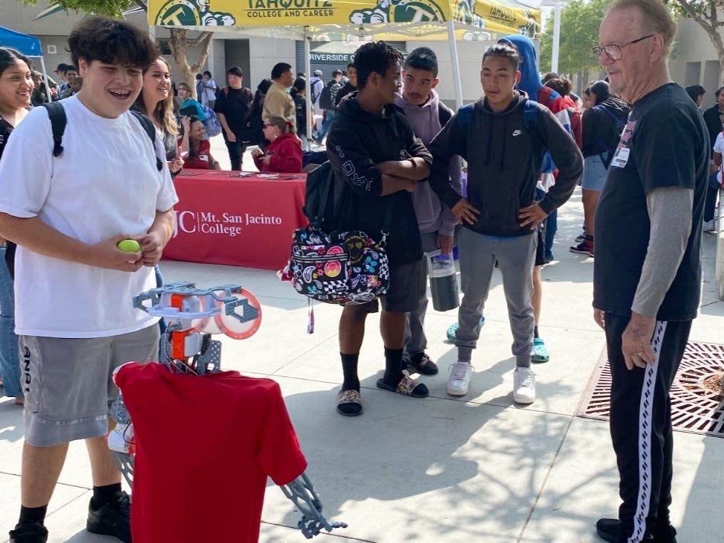 Coach Bob Davies shares voice control tips with kids at a previous STEM Robot event. 