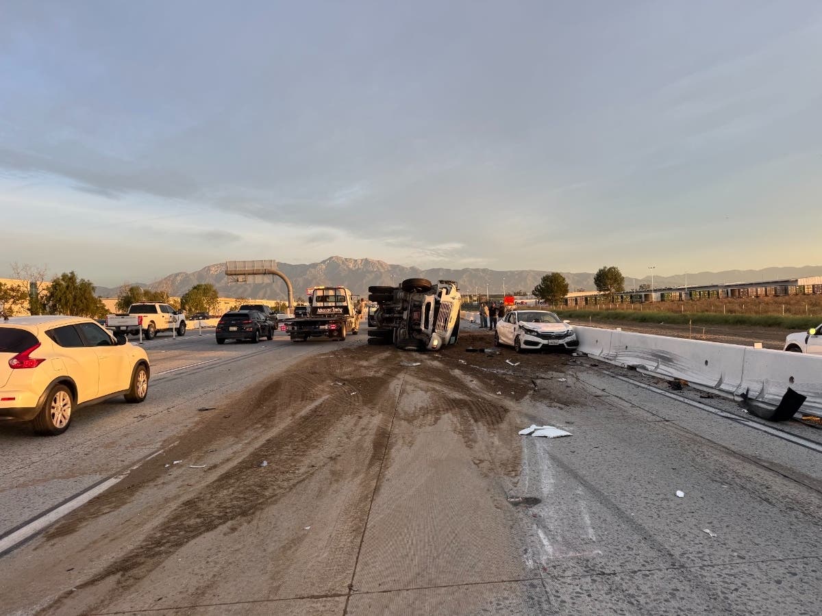 A dump truck scatters sand, dirt, and rocks across the Northbound I-15 Freeway on Monday.