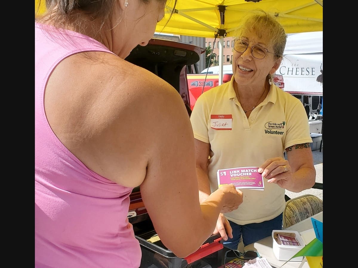 Juliet Ziak, Director of SNAP Matching Grant program, at Northbrook Farmers Market, assists a customer who is doubling her food stamp benefits. 