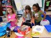 Dinkelmeyer third graders, from left, Isabella Forman, Kaylee Gangi and Katherine Achan began the task of unpacking and organizing their school supplies.