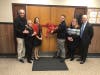 Members of the board of education and administration cut a ribbon signifying the new auditorium seating at Lindell.