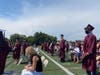 Graduates stand on the Mepham field as administrators call their names for diploma distribution. 