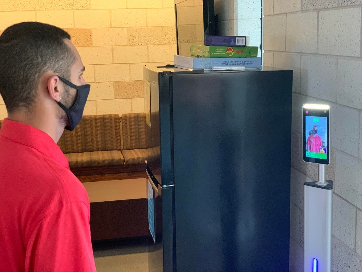Matteo Itri, a Molloy College student, using the temperature kiosk.
