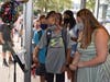 Students held up their wrists to have their temperatures taken by touchless thermometers at the entrance to Saw Mill Road School.