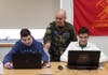 Second Lieutenant Bruce Geller (NY033) works with cadets during CyberPatriot class.