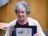 Joan D'Alessandro holds the State Senate Proclamation issued to her late husband Herbert by State Sen. Sue Serino
