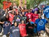 Students from Uncommon Collegiate Charter High School showing off the t-shirts of their colleges during senior signing day.
