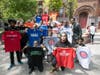 Students from Uncommon Collegiate Charter High School showing off the t-shirts of their colleges during senior signing day.