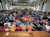 Students from Uncommon Leadership Prep High School showing off the t-shirts of their colleges during senior signing day.