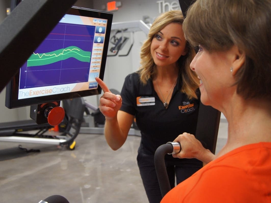 Woman reviews her progress in real time with personal trainer