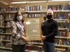 Heights Libraries Director Nancy Levin presents outgoing board president Jim Roosa with a resolution honoring his 10 years of service