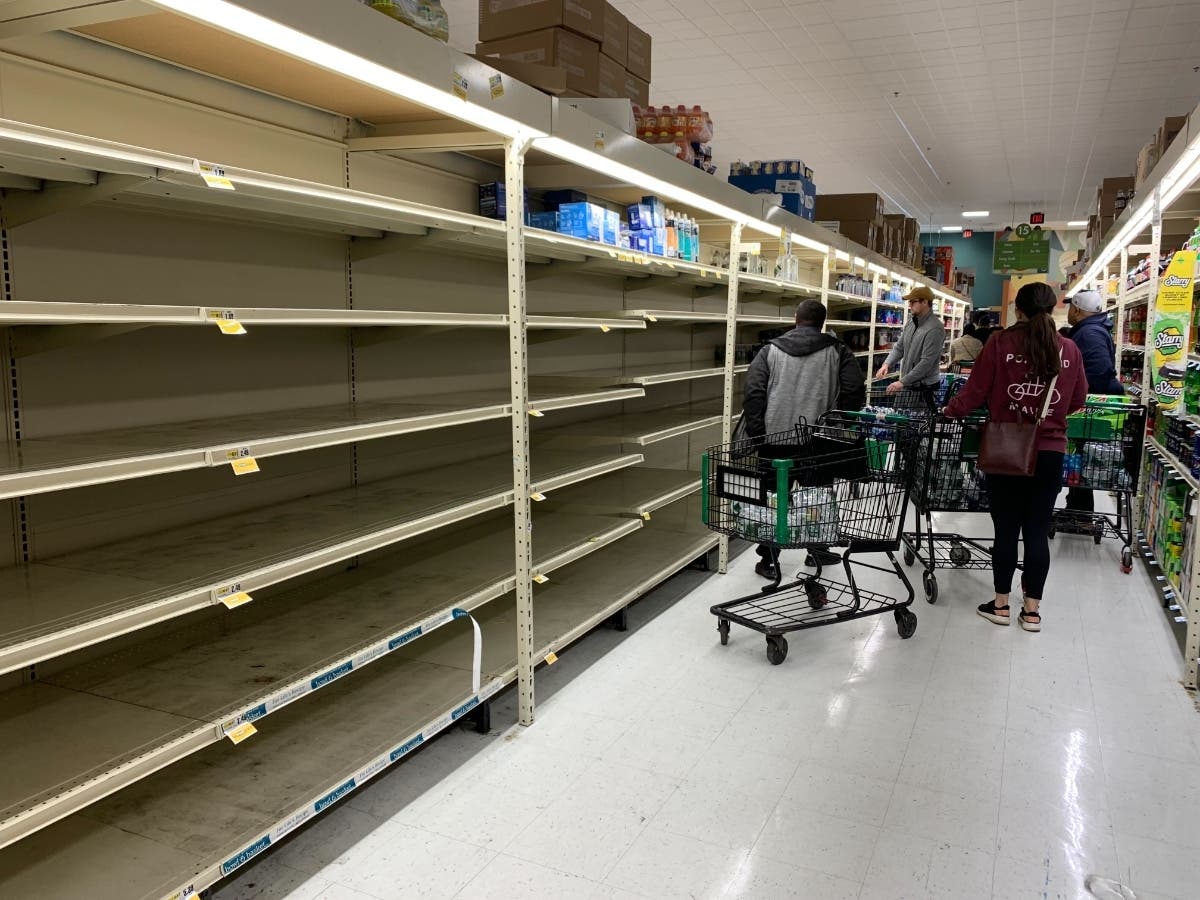 Customers clear shelves of water Sunday at Fresh Grocer in West Philadelphia.
