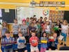 First grade students at Greenwood Elementary School display their new, colorful marker holders, which were created by No