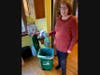 Louise Ward adds food scraps from the day to Black Earth Compost bin.