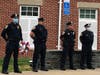 Members of the Clinton Police Department stand at parade rest