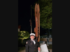 Master of Ceremonies and Ex-Chief Tim Coyle standing next to Twin Tower's steel remnant