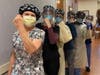 Several St. Vincent Hospital nurses raise their arms in a show of strength against the coronavirus. 