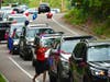 A row of cars drives south down Oak Street. 