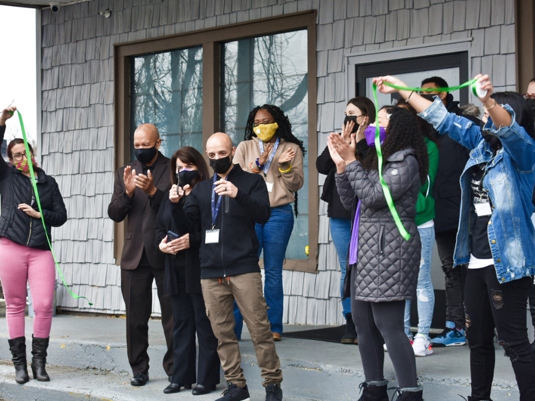 New Día​ owner Ross Bradshaw (center) on Monday morning cutting a green ribbon to open the store. 
