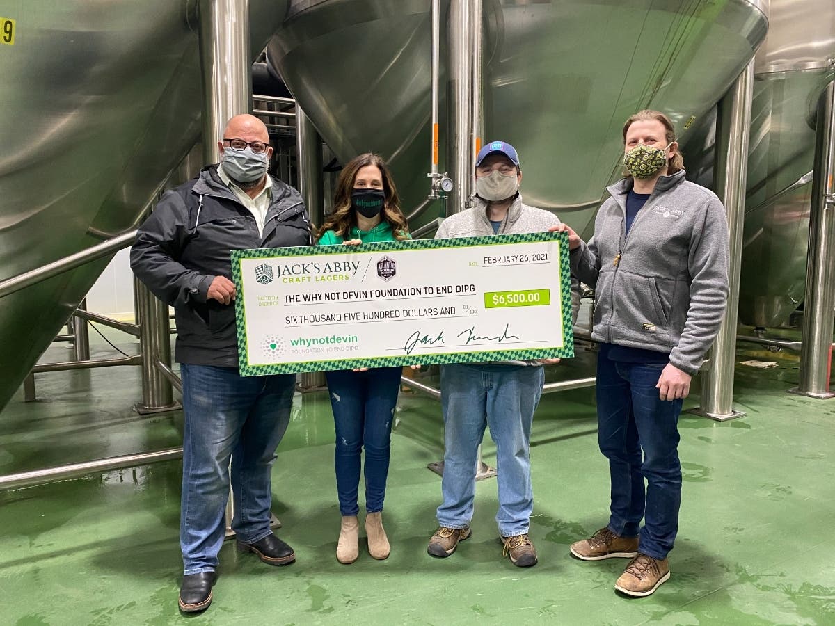 WhyNotDevin founder Christine Suau accepting a $6,500 check from Jack's Abby and Atlantic Beverage Distributors.