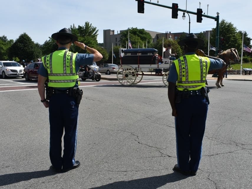 Two state troopers salute Worcester Officer Enmanuel Familia's casket during a funeral procession on June 10.