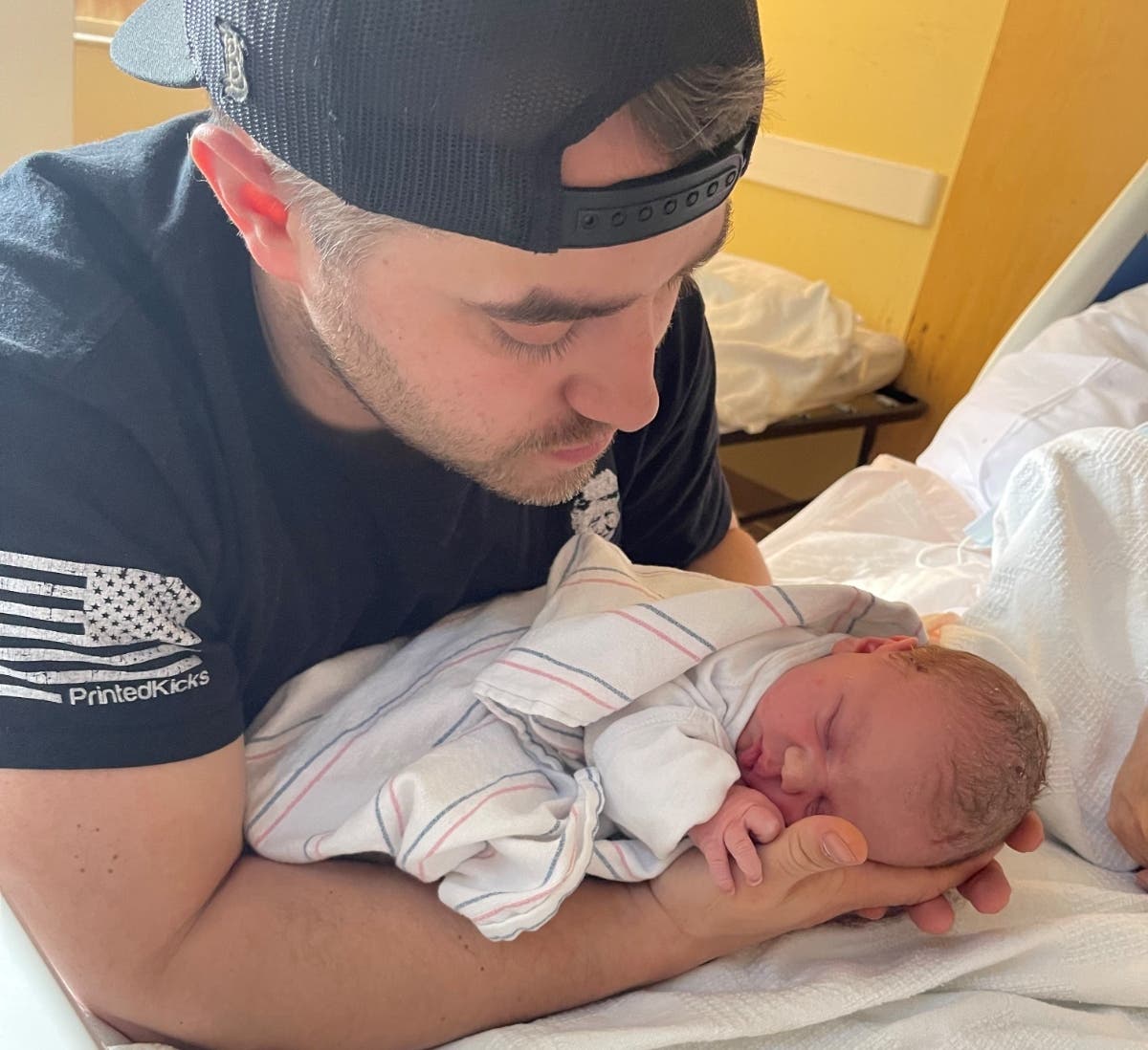 Marlborough firefighter Matt Lupisella holds his daughter, Savannah, whom he delivered along Interstate 290 early Thursday morning.