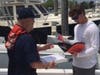 Auxiliary Vessel Examiner discussing required safety equipment for a recreational boat