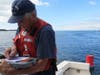 Auxiliarist Aids to Navigation Verifier recording information for navigational aids (buoys) to keep NOAA charts updated